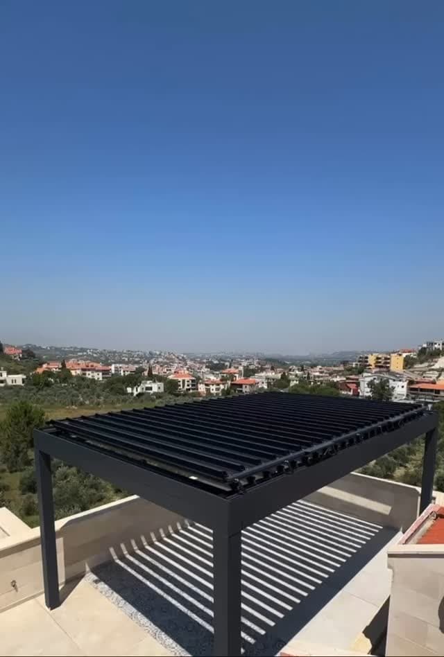 Beyrut'ta çatı terasında siyah bioklimatik pergola ve zeminde lamel gölgeleri